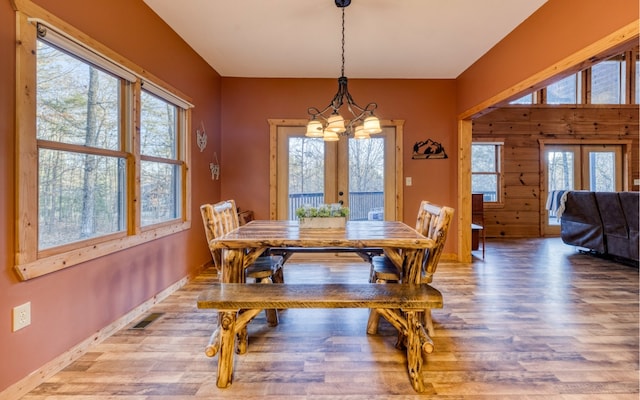 dining room featuring a chandelier, light hardwood / wood-style flooring, and french doors