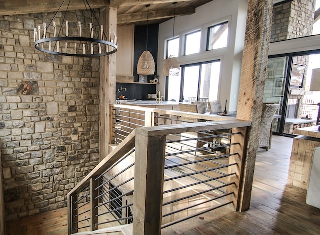 kitchen with beam ceiling, sink, high vaulted ceiling, a chandelier, and wood-type flooring