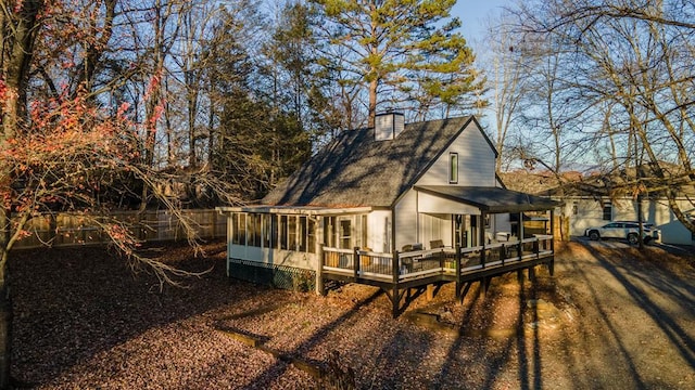 back of property featuring a wooden deck and a sunroom