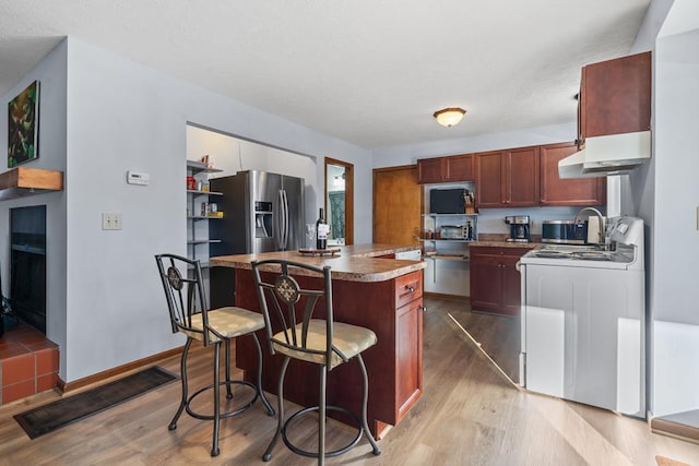 kitchen with a center island, light hardwood / wood-style floors, white range oven, stainless steel fridge with ice dispenser, and extractor fan