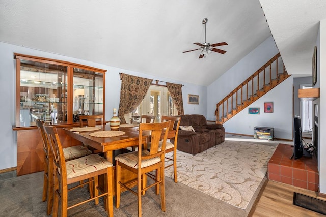 dining space with ceiling fan, light hardwood / wood-style floors, and vaulted ceiling