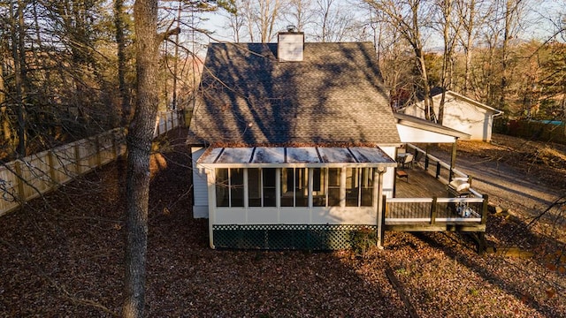 rear view of house with a wooden deck and a sunroom