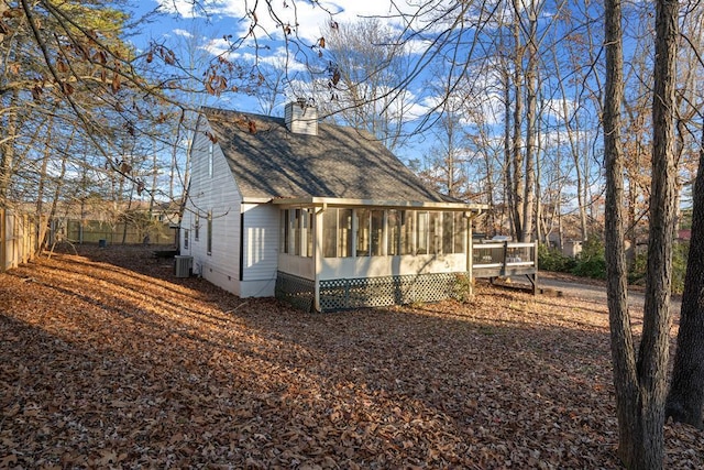 view of home's exterior with central air condition unit and a sunroom