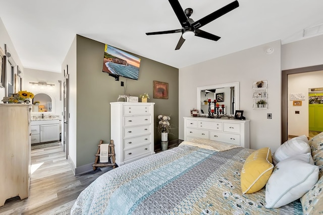 bedroom featuring ceiling fan, light wood-type flooring, and connected bathroom