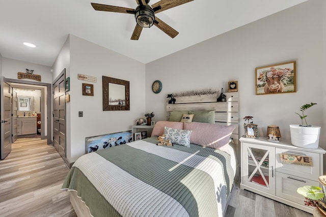 bedroom with ensuite bath, light hardwood / wood-style flooring, and ceiling fan