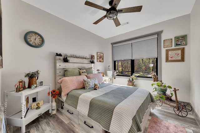 bedroom with ceiling fan, vaulted ceiling, and light hardwood / wood-style flooring