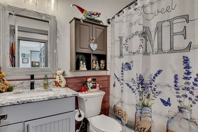 bathroom featuring a shower with shower curtain, vanity, and toilet