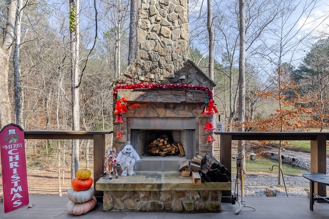 wooden deck with an outdoor stone fireplace