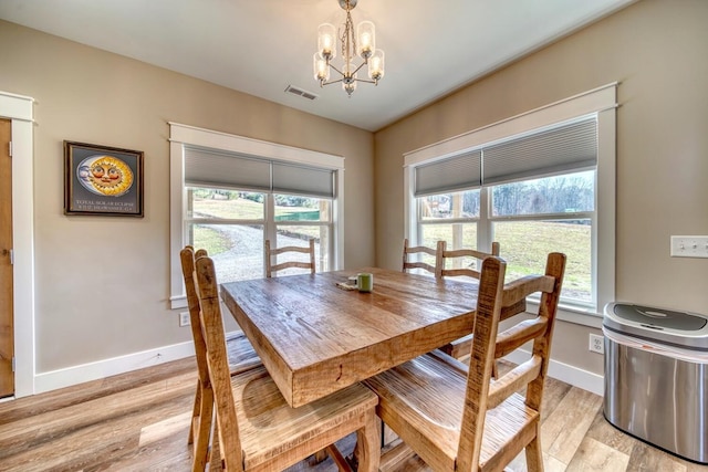 dining room featuring a chandelier, light hardwood / wood-style floors, and a healthy amount of sunlight