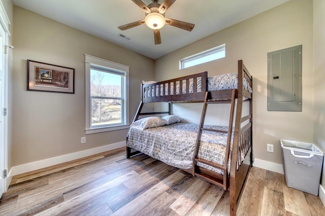 bedroom featuring light wood-type flooring, electric panel, and ceiling fan