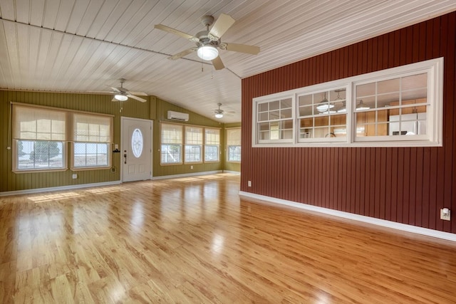 unfurnished living room with baseboards, lofted ceiling, light wood-style flooring, wood ceiling, and a wall mounted air conditioner