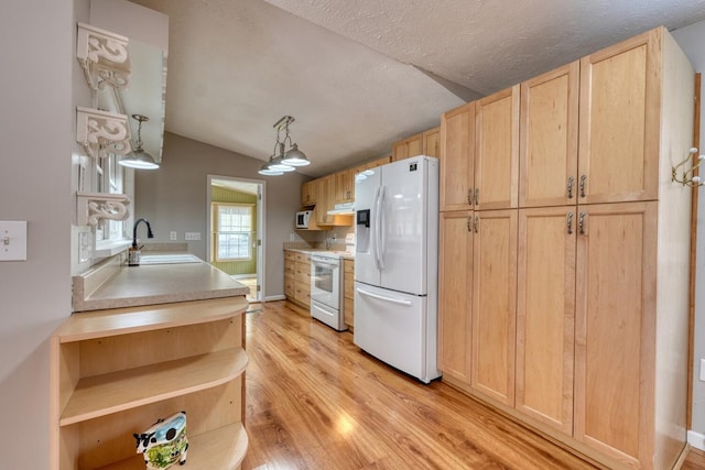 kitchen with a sink, light brown cabinetry, lofted ceiling, white appliances, and open shelves