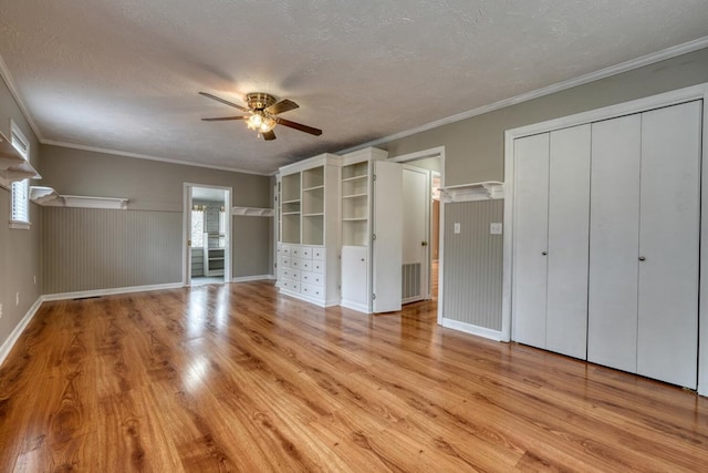 unfurnished bedroom with a ceiling fan, visible vents, ornamental molding, a textured ceiling, and light wood-type flooring