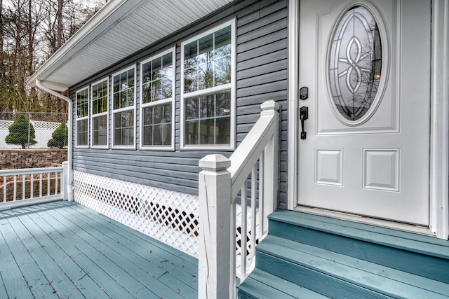 entrance to property with fence and a wooden deck