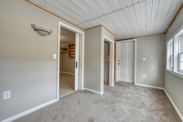 unfurnished bedroom featuring a closet, carpet floors, baseboards, and ornamental molding