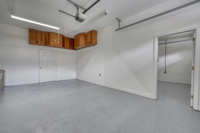 garage featuring a garage door opener and concrete block wall