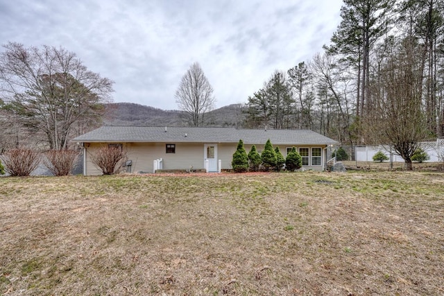 rear view of property with a lawn and fence