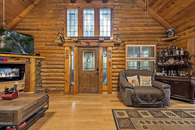 living room with high vaulted ceiling, wood ceiling, light hardwood / wood-style floors, and rustic walls