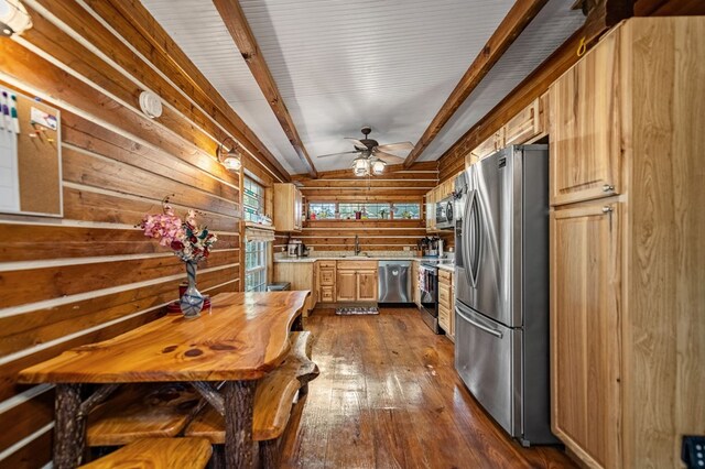 kitchen featuring beamed ceiling, dark wood-type flooring, appliances with stainless steel finishes, ceiling fan, and light brown cabinetry