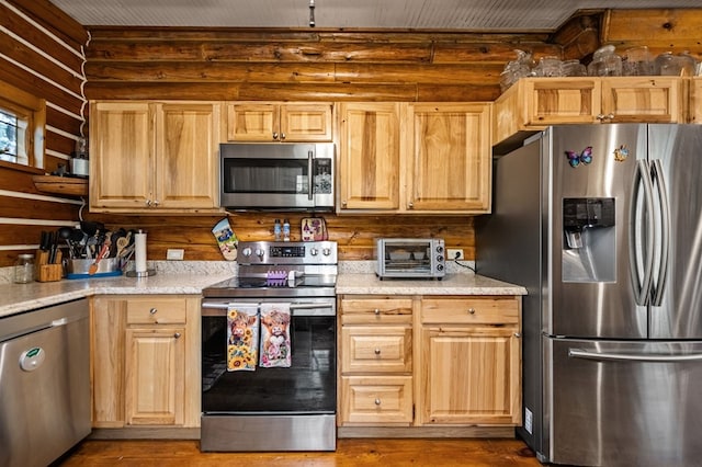 kitchen with wood-type flooring, light brown cabinets, and stainless steel appliances