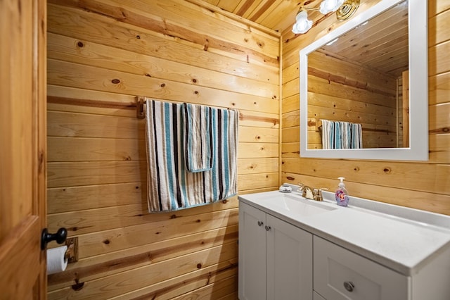 bathroom featuring wood ceiling, wood walls, and vanity