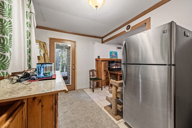 kitchen featuring light carpet, stainless steel refrigerator, and ornamental molding