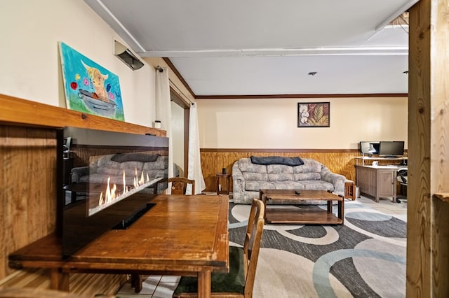 living room with wood walls, light tile patterned flooring, and a stone fireplace