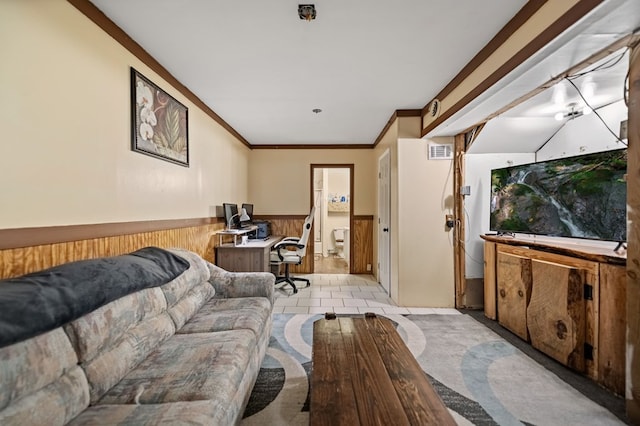 living room with ornamental molding, wood walls, and light tile patterned floors