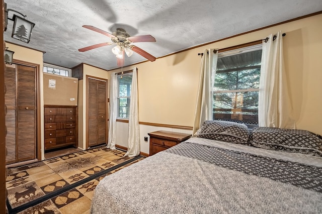 tiled bedroom featuring ceiling fan and a textured ceiling