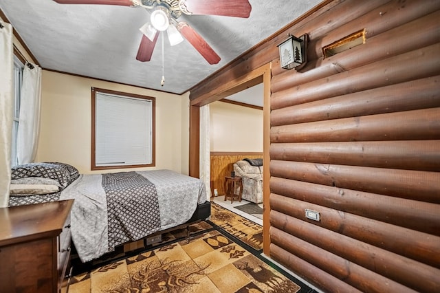 bedroom featuring a textured ceiling, ceiling fan, and rustic walls