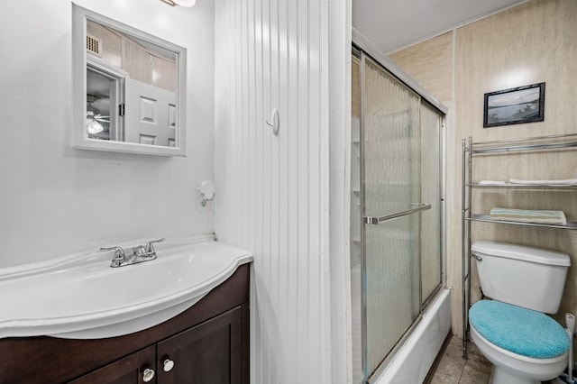 full bathroom with combined bath / shower with glass door, vanity, and toilet