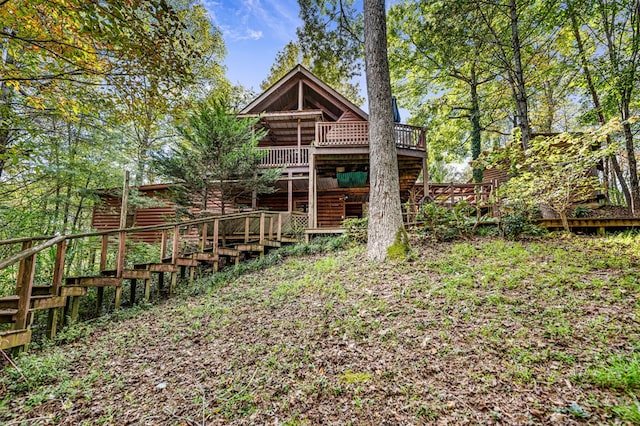 rear view of house featuring a wooden deck