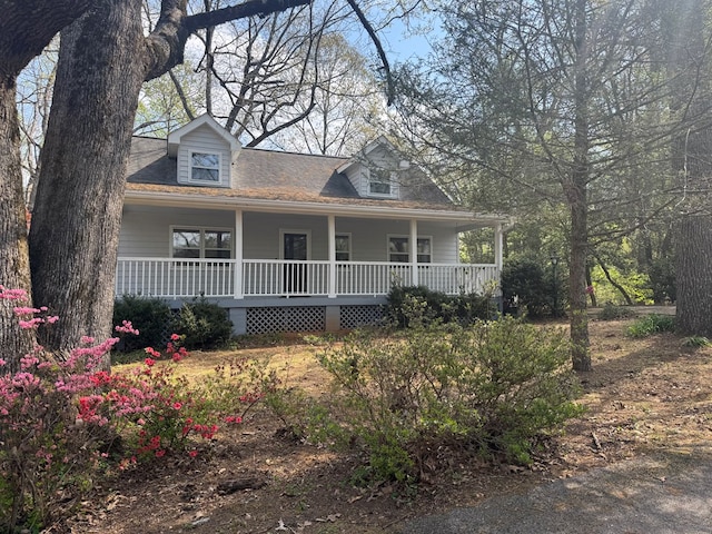 new england style home with covered porch and roof with shingles