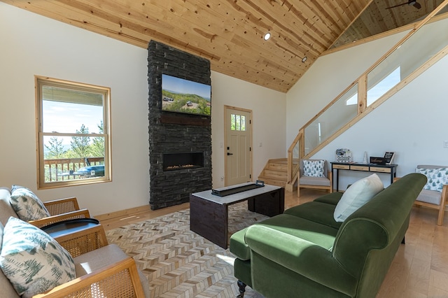 living room featuring high vaulted ceiling, a wealth of natural light, light hardwood / wood-style floors, and wooden ceiling