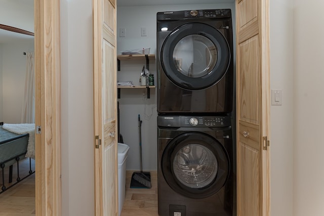 laundry area featuring stacked washer and dryer and light wood-type flooring