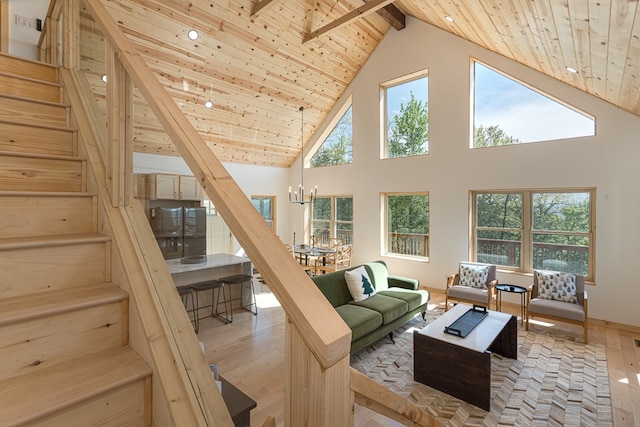 living room with high vaulted ceiling, beamed ceiling, wooden ceiling, and light hardwood / wood-style flooring