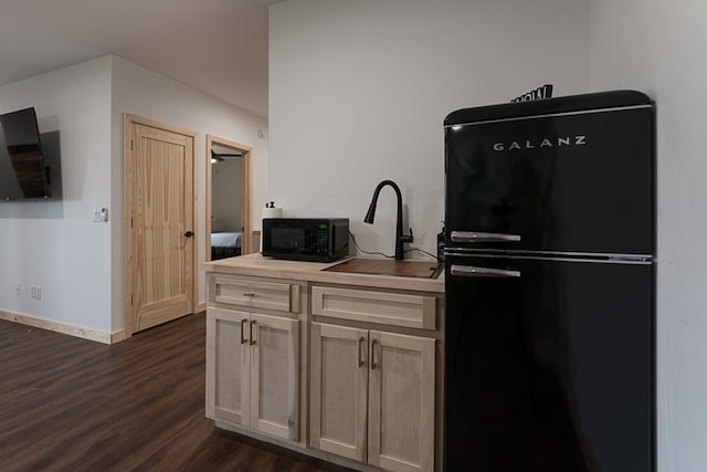 kitchen with black appliances, dark hardwood / wood-style flooring, and sink