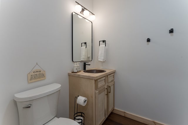 bathroom featuring toilet, vanity, and hardwood / wood-style flooring