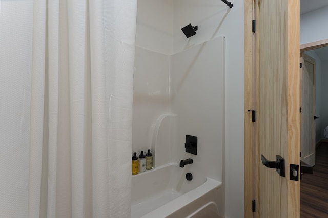 bathroom featuring hardwood / wood-style flooring and shower / bathtub combination with curtain