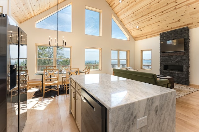 kitchen featuring light hardwood / wood-style floors, light stone counters, wooden ceiling, high vaulted ceiling, and a fireplace