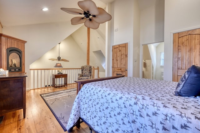 bedroom with wood-type flooring, high vaulted ceiling, and recessed lighting