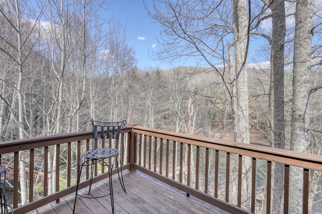 wooden terrace featuring a wooded view