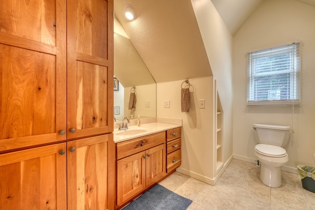 bathroom featuring lofted ceiling, baseboards, vanity, and toilet