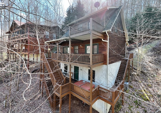 rear view of house featuring a balcony and stairway