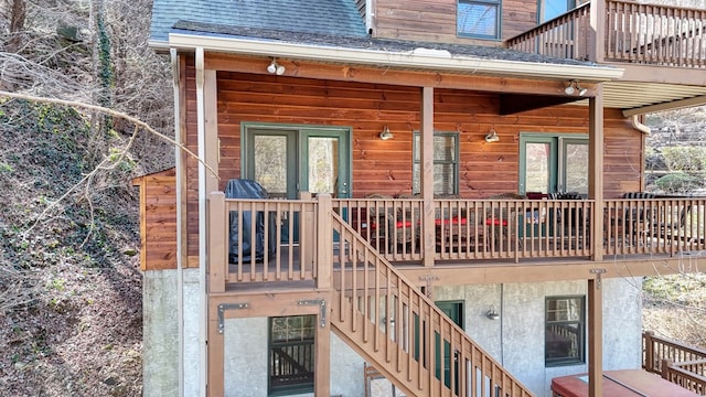 exterior space with stairway and roof with shingles