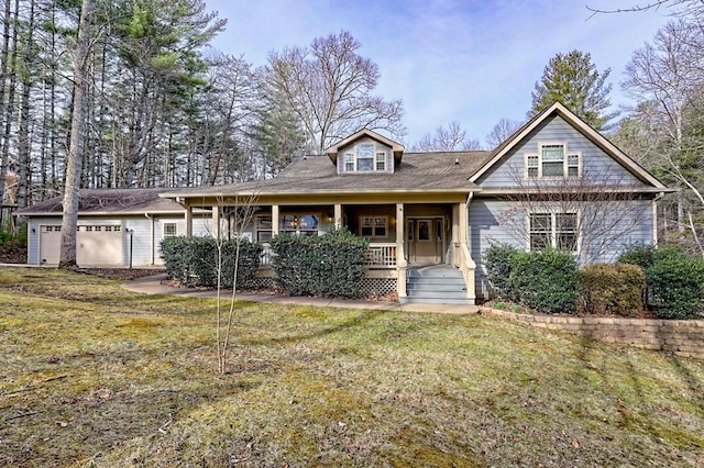 view of front of property featuring covered porch, a front yard, and an attached garage