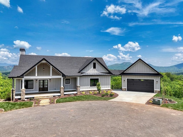 view of front of property with a shingled roof, board and batten siding, driveway, and a chimney