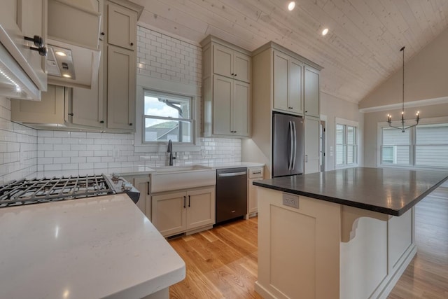 kitchen featuring an inviting chandelier, wood ceiling, appliances with stainless steel finishes, a kitchen island, and tasteful backsplash