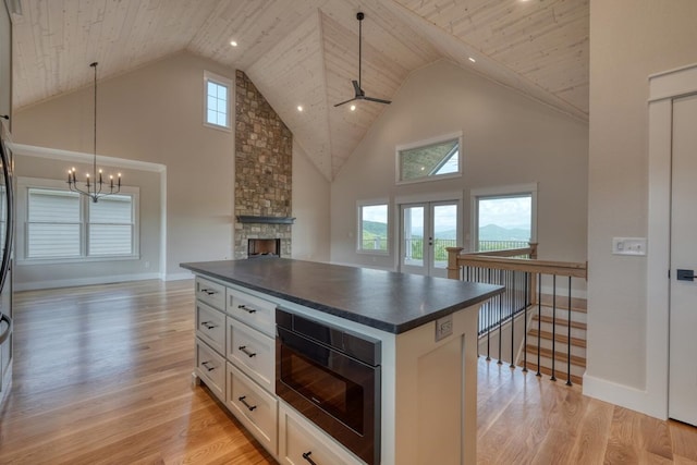 kitchen with dark countertops, wooden ceiling, built in microwave, and high vaulted ceiling