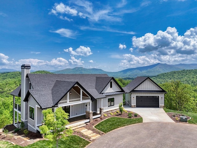 view of front of home featuring a mountain view, concrete driveway, a garage, board and batten siding, and a shingled roof
